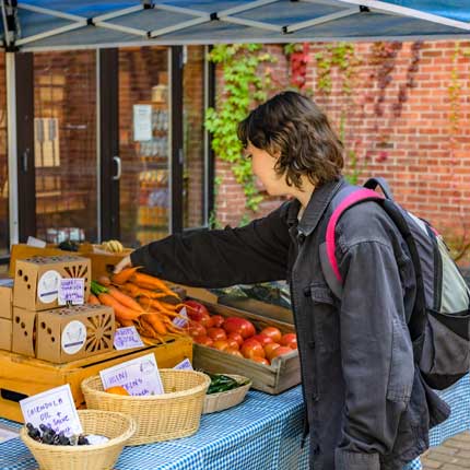 student at a campus farmers market