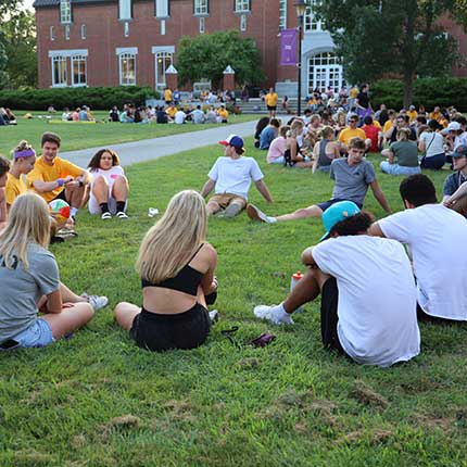 students relaxing on the lawn on campus